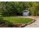 Backyard featuring a grass lawn, garden area, storage shed, and gravel driveway at 427 Cherokee Se Ave, Atlanta, GA 30312