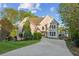Stucco two-story home with a long driveway, stone accents, lush trees, and landscaping on a sunny day at 422 Laurian Nw Way, Kennesaw, GA 30144