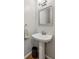 Elegant powder room featuring a pedestal sink, decorative mirror, and modern lighting at 422 Laurian Nw Way, Kennesaw, GA 30144