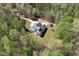 Beautiful aerial view of a two-story home with a front porch, surrounded by dense trees and a trampoline in the yard at 7746 Tyree Rd, Winston, GA 30187