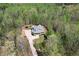 Stunning aerial view of a traditional two story home with a porch surrounded by lush greenery and a long driveway at 7746 Tyree Rd, Winston, GA 30187