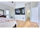 Bright Primary bedroom with a large TV, wood floors, and en-suite bathroom at 7746 Tyree Rd, Winston, GA 30187