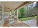 Inviting front porch featuring rocking chairs and scenic views of lush landscaping at 7746 Tyree Rd, Winston, GA 30187