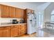 Well-lit kitchen with wooden drawers and cabinets, a white refrigerator and hardwood floors at 7746 Tyree Rd, Winston, GA 30187