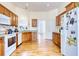 Well-lit kitchen with wooden cabinets, white appliances, and hardwood floors at 7746 Tyree Rd, Winston, GA 30187