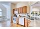 Well-lit kitchen featuring wooden cabinetry, white appliances, and hardwood floors at 7746 Tyree Rd, Winston, GA 30187