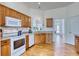 Classic kitchen with wooden cabinets, white appliances, and hardwood floors at 7746 Tyree Rd, Winston, GA 30187