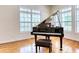 Bright living room with a hardwood floor and an elegant black grand piano at 7746 Tyree Rd, Winston, GA 30187