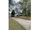 View of the home's exterior with long driveway and landscaping; trees in the background at 30 Dogwood Trl, Dallas, GA 30157