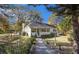 Cozy white cottage-style home surrounded by a mature canopy of trees and lush landscaping at 30 Dogwood Trl, Dallas, GA 30157
