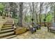 Relaxing backyard deck with stone patio, wooden steps, and peaceful wooded views at 3230 Riverhill Ct, Cumming, GA 30041