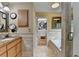 Bright bathroom with walk-in closet, soaking tub, and neutral tile throughout at 3230 Riverhill Ct, Cumming, GA 30041
