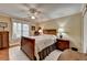 Cozy bedroom featuring a decorative bed frame, ceiling fan, and natural light from the window at 3230 Riverhill Ct, Cumming, GA 30041