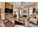 Spacious living room featuring hardwood floors, fireplace, ceiling fan and comfortable leather furniture at 3230 Riverhill Ct, Cumming, GA 30041