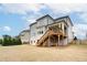 Expansive backyard with a two-story house, deck, lush greenery, and open space for outdoor activities at 4495 Alister Park Dr, Cumming, GA 30040