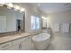 Luxurious bathroom boasting a soaking tub, stone countertops and elegant fixtures at 4495 Alister Park Dr, Cumming, GA 30040