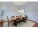Well-lit dining room with seating for eight, hardwood floors, wainscoting and decorative chandelier at 4495 Alister Park Dr, Cumming, GA 30040
