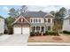 Beautiful two-story home with manicured lawn, a two car garage and covered front porch entry at 4495 Alister Park Dr, Cumming, GA 30040