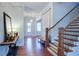 Inviting foyer featuring hardwood floors, a staircase, and a decorative table with mirror at 4495 Alister Park Dr, Cumming, GA 30040