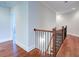 Upstairs hallway with hardwood flooring and a staircase featuring iron railings and wooden accents at 4495 Alister Park Dr, Cumming, GA 30040