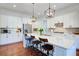 Bright kitchen boasts white cabinets, stainless steel appliances, hardwood floors, and a large center island with seating at 4495 Alister Park Dr, Cumming, GA 30040