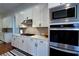 Modern kitchen features stainless steel appliances, white cabinets, and a sleek countertop with backsplash at 4495 Alister Park Dr, Cumming, GA 30040