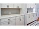 Kitchen with white cabinets and countertops, accented by gray backsplash and a striped rug at 4495 Alister Park Dr, Cumming, GA 30040
