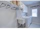 Well-organized laundry room with washer, dryer, sink, hanging rod, and white shelving for ample storage space at 4495 Alister Park Dr, Cumming, GA 30040