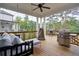 Covered outdoor patio with a porch swing, grill, dining table, and overhead fan for relaxation and entertaining at 4495 Alister Park Dr, Cumming, GA 30040