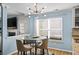 Cozy breakfast nook featuring a glass-top table, four chairs, modern light fixture and a large window at 543 Walnut Way, Palmetto, GA 30268