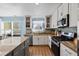 Bright kitchen featuring white cabinetry, stainless appliances, granite countertops and wood floors at 543 Walnut Way, Palmetto, GA 30268