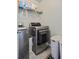 Modern laundry room with gray washer and dryer and storage shelves for a functional and organized space at 543 Walnut Way, Palmetto, GA 30268