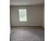A simple bedroom with neutral walls, carpet, and a window with blinds allowing natural light at 6426 Rosetta Drive # 53, South Fulton, GA 30331