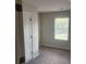 A bright bedroom featuring neutral carpet, a window with blinds, and a crisp white door at 6426 Rosetta Drive # 53, South Fulton, GA 30331