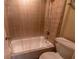 Bathroom featuring a shower/tub combo with neutral colored tile walls and shower curtain at 177 Nw Amherst Pl, Atlanta, GA 30327