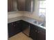 A kitchen with stainless steel appliances, dark wood cabinets, and granite countertops at 2598 Miriam Ln, Decatur, GA 30032