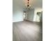 Open-concept living room with modern chandelier and sleek gray flooring, perfect for entertaining at 3058 Arden Ridge Ter, Suwanee, GA 30024