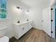 Modern bathroom with double sink vanity, luxury vinyl floors, and contemporary lighting at 5215 Virginia Ave, Cumming, GA 30041