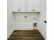 Functional laundry area with white cabinets, luxury vinyl floors, and modern amenities at 5215 Virginia Ave, Cumming, GA 30041