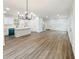 Spacious living room and kitchen with an elegant chandelier and wood-look flooring at 5215 Virginia Ave, Cumming, GA 30041