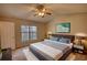 Bedroom with large window, ceiling fan, and neutral carpet with furnished bed and art at 5587 Strathmoor Manor Cir, Lithonia, GA 30058