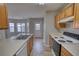 A bright kitchen featuring wood cabinets and sleek countertops and view into the dining area at 5587 Strathmoor Manor Cir, Lithonia, GA 30058