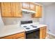 Kitchen featuring wood cabinets and a white electric range at 5587 Strathmoor Manor Cir, Lithonia, GA 30058
