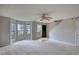Living room showcasing plush carpet and natural light with bay window and staircase access at 5587 Strathmoor Manor Cir, Lithonia, GA 30058