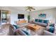 Well-lit living room featuring a ceiling fan, neutral walls, and views into the dining area at 5587 Strathmoor Manor Cir, Lithonia, GA 30058