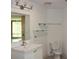 Bright bathroom featuring a single sink vanity, a toilet, glass shelves, and a large mirror at 319 Atlanta Se St # 317, Marietta, GA 30060