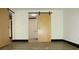 Bedroom with wood-look floors features a modern sliding barn door leading to bathroom at 319 Atlanta Se St # 317, Marietta, GA 30060