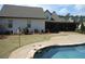 Exterior view of home showcasing a screened in back porch area and a large in ground pool at 325 Brook Hollow Ln, Loganville, GA 30052
