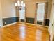 Bright dining room features hardwood floors, modern chandelier, and two windows with attractive curtains at 325 Brook Hollow Ln, Loganville, GA 30052