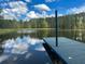 Close-up of a dock extending into a serene pond with a reflective surface at 325 Brook Hollow Ln, Loganville, GA 30052